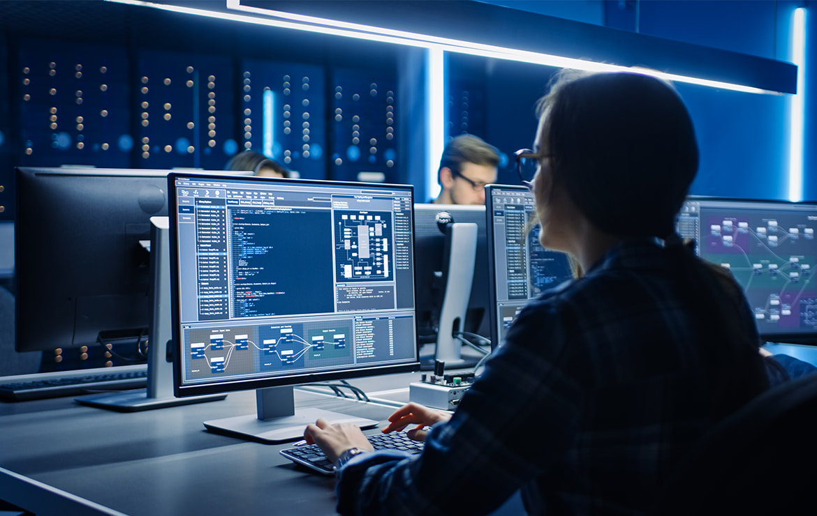 Pessoa trabalhando na frente de computadores