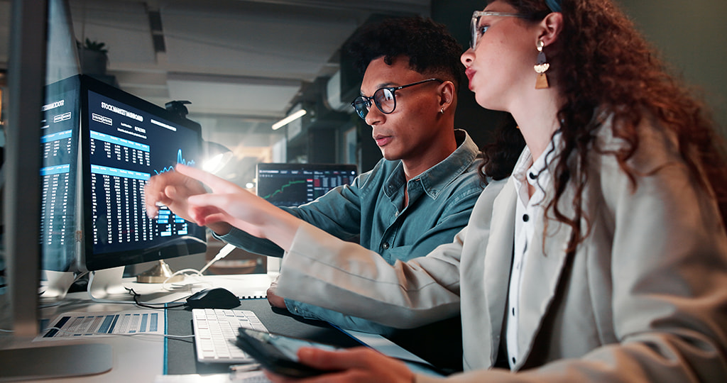 Duas pessoas trabalhando em frente a um computador