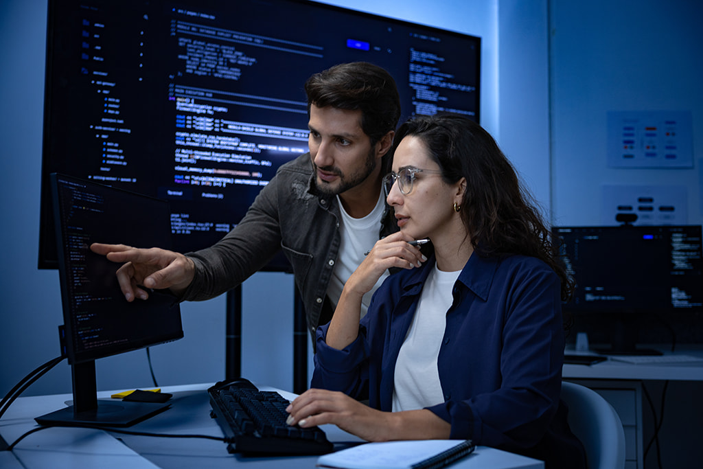 Duas pessoas trabalhando em frente a um computador
